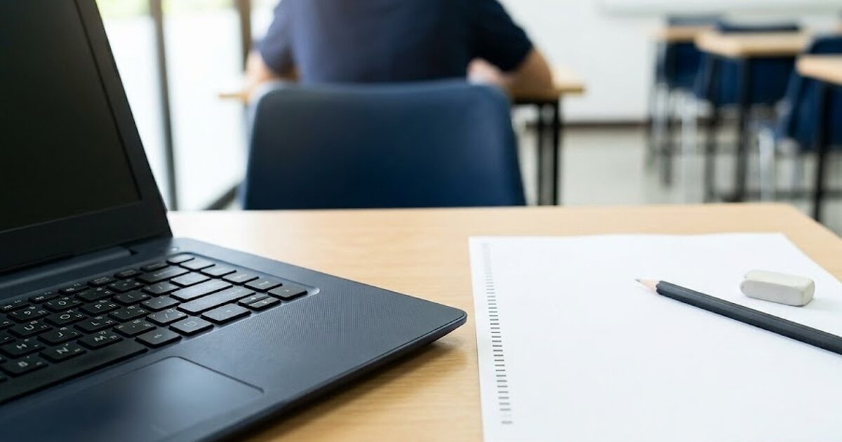 Laptop và phiếu trả lời đặt cạnh nhau, minh họa lựa chọn thi TOPIK IBT hay thi trên giấy